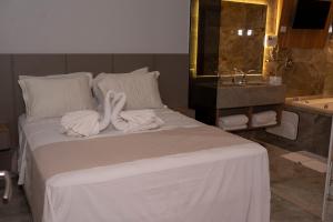 two swans towels on a bed in a bathroom at Hotel Entre Rios in Pontalina +20 photos