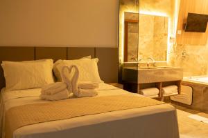a hotel room with a bed with towels on it at Hotel Entre Rios in Pontalina