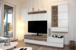 a living room with a flat screen tv on a cabinet at Ostseebrise in Grömitz