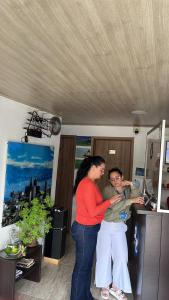 a woman standing next to a man in a room at Hotel La Castellana in Manizales