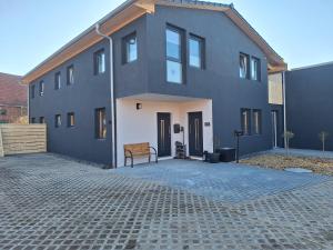 a gray house with a bench in front of it at Apartment am Gestütswegs EG 2 in Alt Krenzlin