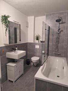 a bathroom with a sink and a tub and a toilet at Apartment am Gestütswegs EG 2 in Alt Krenzlin +9 photos