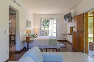 a bedroom with a bed and a living room at Fazenda Montanhas do Japi in Jundiaí