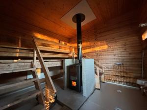 a fireplace in a room with a wooden wall at Kyly in Savonlinna
