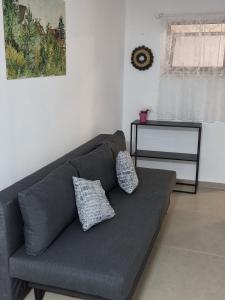 a gray couch with two pillows in a living room at מקום למשפחה in Kefar Tavor