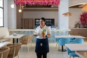 a woman standing in a restaurant holding a drink at Hotel Presidente Beach Salinas in Salinas +187 photos