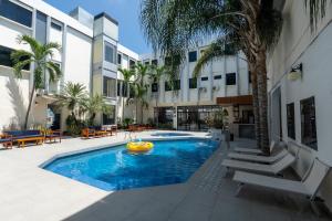 a pool with a frisbee in front of a building at Hotel Presidente Beach Salinas in Salinas