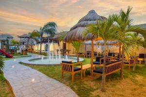 a resort with a pool and chairs and a fountain at Hotel Presidente Beach Salinas in Salinas