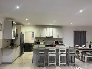 a large kitchen with white cabinets and a table at West Coast comfortable stays in Cape Town