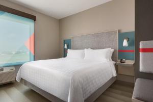 a bedroom with a large white bed and a window at avid hotels - Salem by IHG in Salem