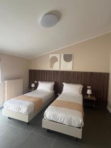a bedroom with two beds and two tables with lamps at Da Paola 