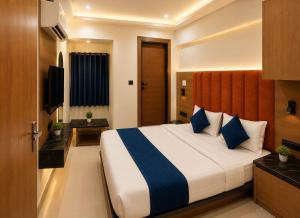 a hotel room with a bed and a television at HOTEL CAMPUS in Ahmedabad