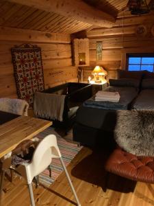 a log cabin with a living room with a bed and a table at Log cabin in rural surroundings in Stjoerdal
