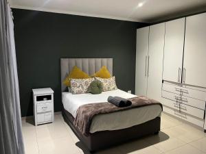 a bedroom with a bed and a black wall at West Coast comfortable stays in Cape Town