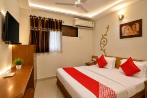 a bedroom with a bed and a desk and a television at HOTEL CAMPUS in Ahmedabad +11 photos