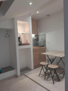 a kitchen with a table and stools in a room at Serge Le Belge - Sejour authentique chez l habitant a Lezignan Corbieres in Lézignan-Corbières