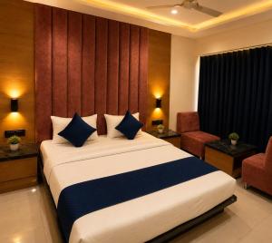 a bedroom with a large bed with blue pillows at HOTEL CAMPUS in Ahmedabad