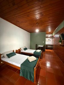 a large room with two beds and a kitchen at Iguazú Garden Lodge in Puerto Iguazú