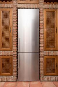 a stainless steel refrigerator in front of a brick wall at Casa espaciosa cerca de Monachil in La Zubia +10 photos
