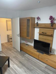 a living room with a tv on a wooden entertainment center at Ferienwohnung Traumschleife Klettersteig in Boppard