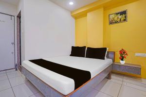a large bed in a room with yellow walls at Hotel O Unity Guest House in Dabhoi