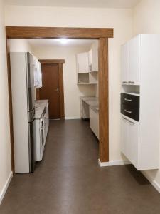 an empty kitchen with white cabinets and appliances at Pousada CTI in Taubaté