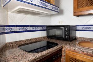 a microwave oven sitting on a counter in a kitchen at Casa espaciosa cerca de Monachil in La Zubia
