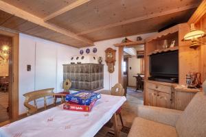 a living room with a table and a television at Hütte Wilfried in Hainzenberg