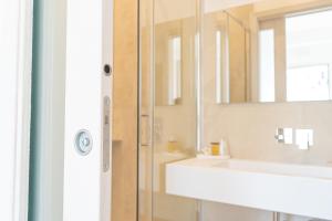 a bathroom with a sink and a mirror at Viver Guest House in La Caletta