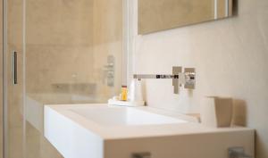 a bathroom with a white sink and a shower at Viver Guest House in La Caletta