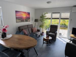 a living room with a table and chairs at Luxe Chalet San Marco in Giethoorn