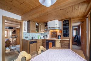 a kitchen with wooden cabinets and a table in a room at Hütte Wilfried in Hainzenberg
