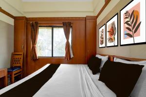 a bedroom with a large bed with a window at Hotel O Stay First in Coimbatore