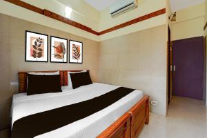 a bedroom with a large bed in a room at Hotel O Stay First in Coimbatore +24 photos