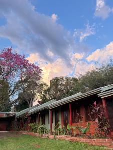 a red building with trees in the background at Iguazú Garden Lodge in Puerto Iguazú