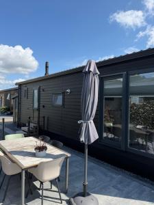 a patio with a table and an umbrella at Luxe Chalet San Marco in Giethoorn