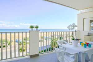 a balcony with a table and chairs and the ocean at Residence A-More in Rimini
