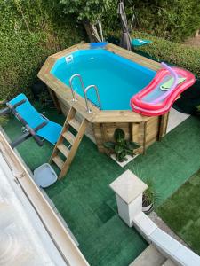 an overhead view of a swimming pool with a table and a slide at Le Cocoon caché avec piscine parking,terrasse au calme appartement très frais ! in Sarreguemines