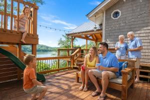 a family sitting on the deck of a house at Ultimate Lake Norris Getaway with Private Dock in New Tazewell