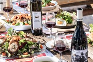 a table with plates of food and a bottle of wine at Cabane Bella-Tola in Saint-Luc
