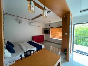 a bedroom with a bed and a table and a window at Blue Hills Resort Vythiri in Vythiri