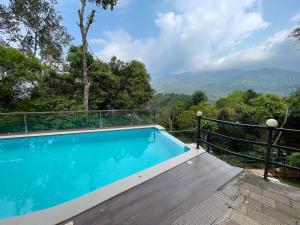 a swimming pool with a view of the mountains at Blue Hills Resort Vythiri in Vythiri