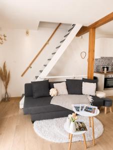 a living room with a couch and a table at Joli triplex proche Colmar in Sainte-Croix-en-Plaine
