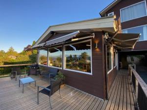 a deck with chairs and tables on a building at Hostal Lago Ranco Boutique in Lago Ranco