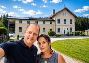 a man and a woman standing in front of a house at Lavanttalbahn Suite in Bad Sankt Leonhard im Lavanttal
