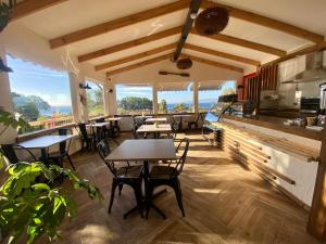 a restaurant with tables and chairs and windows at Hostal Lago Ranco Boutique in Lago Ranco