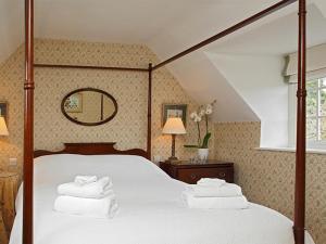 A bed or beds in a room at Wychwood Cottage