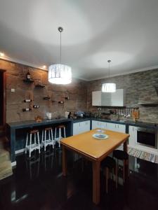 a kitchen with a wooden table and some lights at Casa da Aldeia in Santa Cruz do Douro