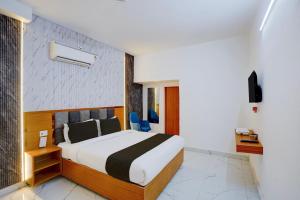 a hotel room with a bed and two blue chairs at Hotel O A5 Blue in Gorakhpur +27 photos