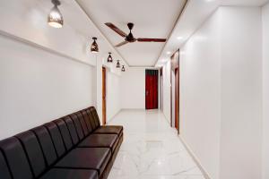 a living room with a couch and a red door at Hotel O A5 Blue in Gorakhpur